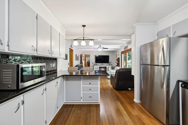 1148 Green Valley Dr, Lewisburg, TN 37091 - kitchen featuring stainless steel appliances, ceiling fan, dark countertops, tasteful backsplash, and a peninsula