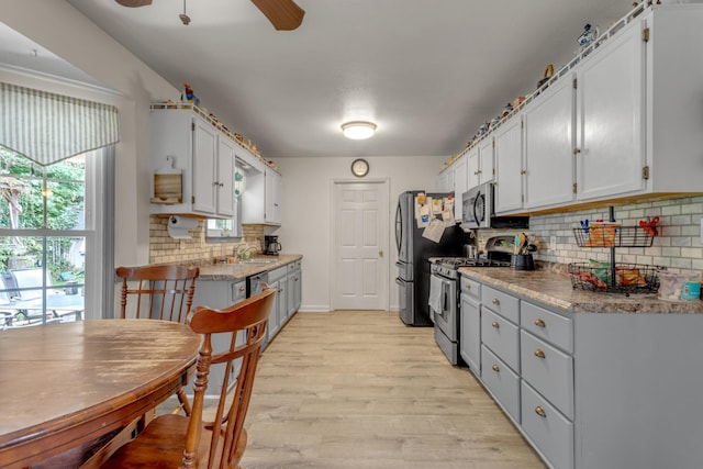 1530 Potter Dr, Columbia, TN 38401 - kitchen featuring appliances with stainless steel finishes, backsplash, ceiling fan, light wood-style flooring, and white cabinets