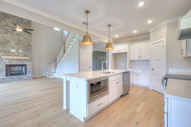4016 Runyan Cv, Murfreesboro, TN 37127 - kitchen with stainless steel appliances, crown molding, light wood finished floors, light countertops, and white cabinetry