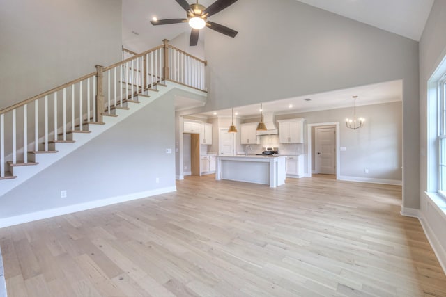 4016 Runyan Cv, Murfreesboro, TN 37127 - unfurnished living room with high vaulted ceiling, a chandelier, stairway, ceiling fan, and light wood finished floors