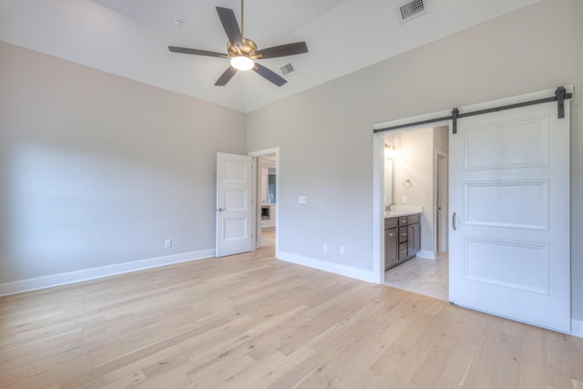 4016 Runyan Cv, Murfreesboro, TN 37127 - unfurnished bedroom featuring a barn door, light wood-type flooring, ensuite bathroom, and a ceiling fan