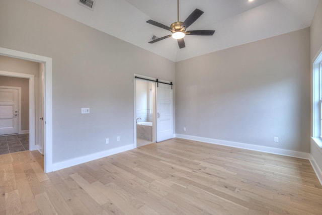 4016 Runyan Cv, Murfreesboro, TN 37127 - unfurnished bedroom featuring a barn door, light wood-type flooring, connected bathroom, and ceiling fan