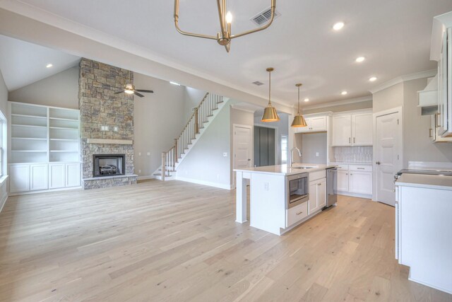 4016 Runyan Cv, Murfreesboro, TN 37127 - kitchen featuring stainless steel appliances, white cabinets, light wood-style floors, decorative light fixtures, and crown molding