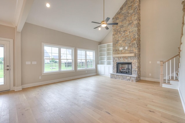 4016 Runyan Cv, Murfreesboro, TN 37127 - unfurnished living room featuring light wood-type flooring, a ceiling fan, stairs, built in features, and a stone fireplace