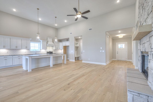 5560 Sinclair Ct, Murfreesboro, TN 37127 - kitchen featuring white cabinets, a high ceiling, backsplash, light wood-style flooring, and a ceiling fan