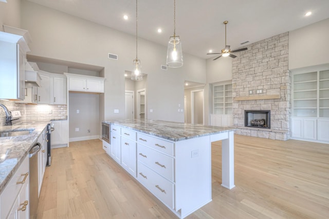 5560 Sinclair Ct, Murfreesboro, TN 37127 - kitchen with ceiling fan, a kitchen island, white cabinets, light wood finished floors, and a towering ceiling