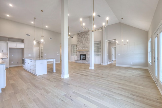 5560 Sinclair Ct, Murfreesboro, TN 37127 - unfurnished living room with high vaulted ceiling, a chandelier, a ceiling fan, a fireplace, and light wood-style floors