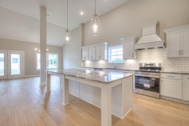 5560 Sinclair Ct, Murfreesboro, TN 37127 - kitchen with premium range hood, stainless steel range with electric stovetop, high vaulted ceiling, a kitchen island, and decorative backsplash
