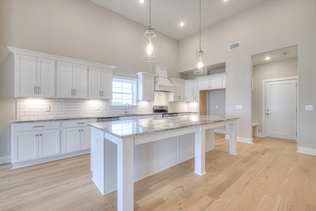 5560 Sinclair Ct, Murfreesboro, TN 37127 - kitchen with high vaulted ceiling, decorative backsplash, white cabinetry, light stone countertops, and a center island