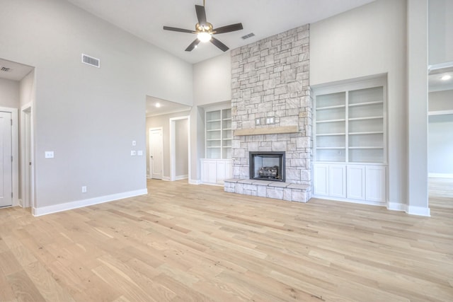 5560 Sinclair Ct, Murfreesboro, TN 37127 - unfurnished living room featuring a towering ceiling, a ceiling fan, wood finished floors, built in features, and a stone fireplace
