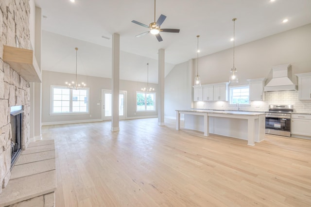 5560 Sinclair Ct, Murfreesboro, TN 37127 - unfurnished living room featuring high vaulted ceiling, a chandelier, light wood finished floors, a stone fireplace, and ceiling fan