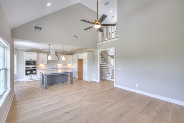 4113 Cile Ct, Murfreesboro, TN 37127 - kitchen with stainless steel appliances, white cabinets, a kitchen breakfast bar, high vaulted ceiling, and a ceiling fan