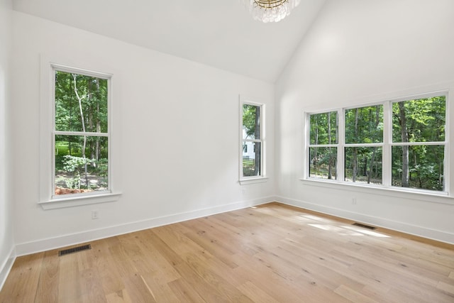 1007 Pheasant Ct, Kingston Springs, TN 37082 - unfurnished room with plenty of natural light, a chandelier, light wood-style floors, and high vaulted ceiling