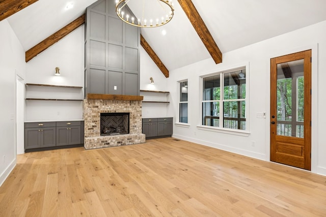 1007 Pheasant Ct, Kingston Springs, TN 37082 - unfurnished living room featuring light wood finished floors, beamed ceiling, a chandelier, high vaulted ceiling, and a brick fireplace
