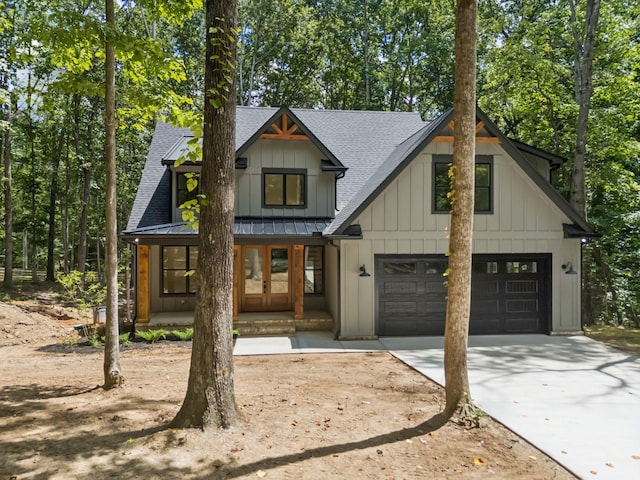 1007 Pheasant Ct, Kingston Springs, TN 37082 - modern farmhouse featuring roof with shingles, concrete driveway, a standing seam roof, board and batten siding, and a porch