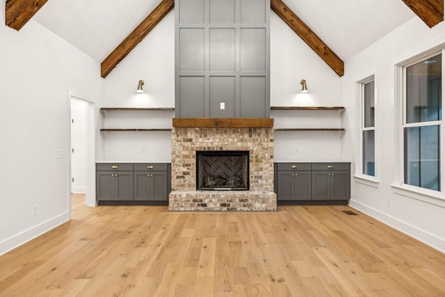 1007 Pheasant Ct, Kingston Springs, TN 37082 - unfurnished living room featuring high vaulted ceiling, beamed ceiling, light wood finished floors, and a brick fireplace