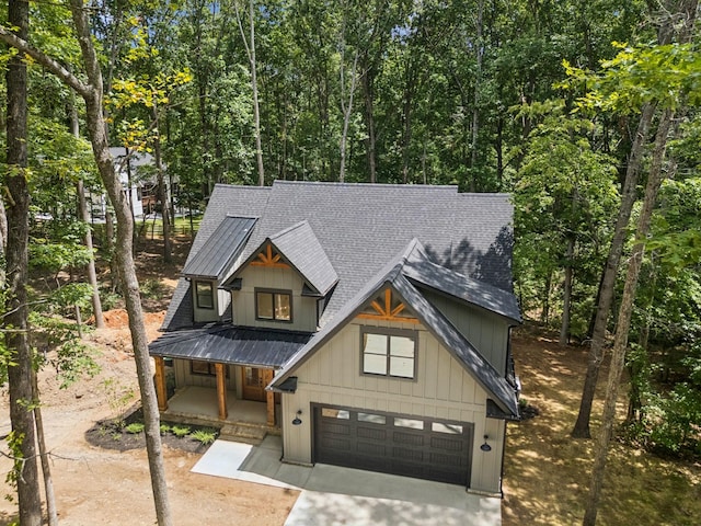 1007 Pheasant Ct, Kingston Springs, TN 37082 - view of front of property featuring roof with shingles, driveway, covered porch, a garage, and a metal roof