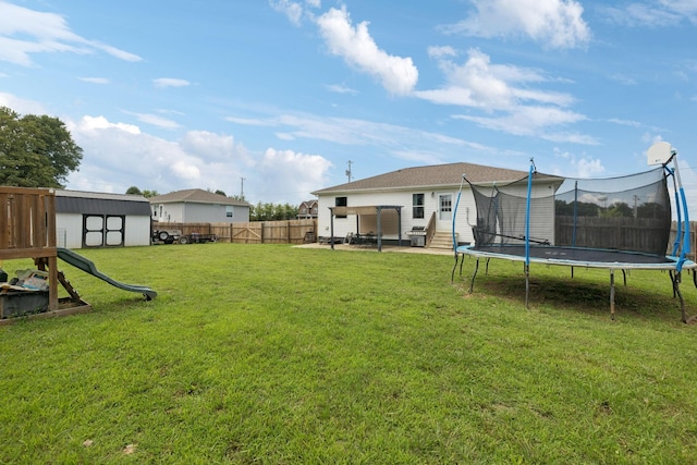 906 Freeman St, Lafayette, TN 37083 - fenced backyard with a trampoline, a patio area, a storage unit, and a playground