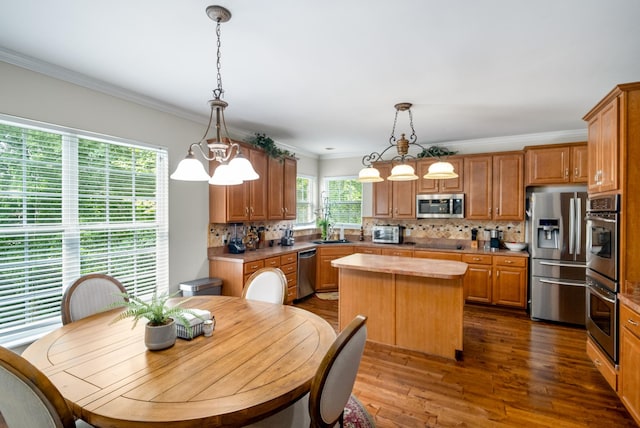 4305 Minette Ct, Mount Juliet, TN 37122 - kitchen with stainless steel appliances, a center island, decorative backsplash, crown molding, and dark wood finished floors