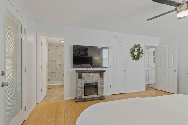 7115 Littlejohn Ln, Fairview, TN 37062 - bedroom with light wood-style floors, a stone fireplace, ensuite bathroom, and a ceiling fan