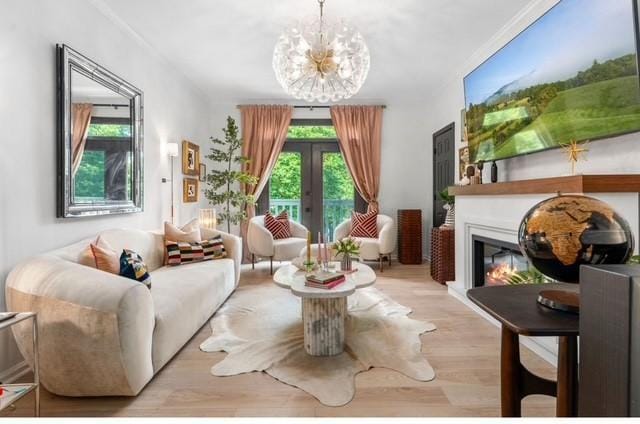 2083 Stokes Ln, Nashville, TN 37215 - sitting room with wood finished floors, a glass covered fireplace, a chandelier, crown molding, and french doors
