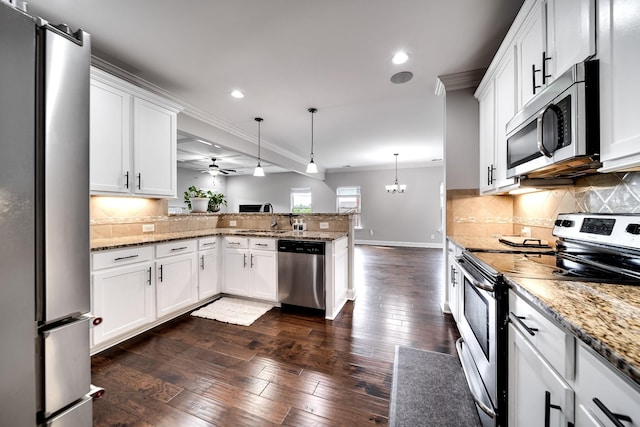 230 Fowler Cir, Franklin, TN 37064 - kitchen featuring stainless steel appliances, a peninsula, crown molding, dark wood-style floors, and decorative backsplash