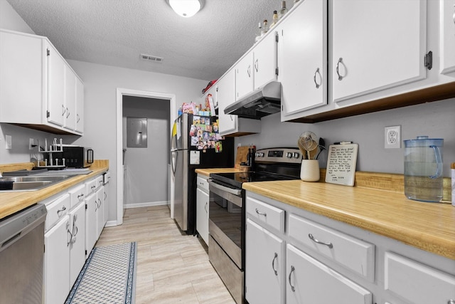 3222 Joselin Ln, Chattanooga, TN 37415 - kitchen featuring stainless steel appliances, under cabinet range hood, white cabinetry, light countertops, and a textured ceiling