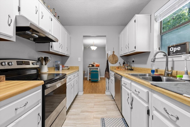 3222 Joselin Ln, Chattanooga, TN 37415 - kitchen with appliances with stainless steel finishes, under cabinet range hood, white cabinetry, light countertops, and a textured ceiling