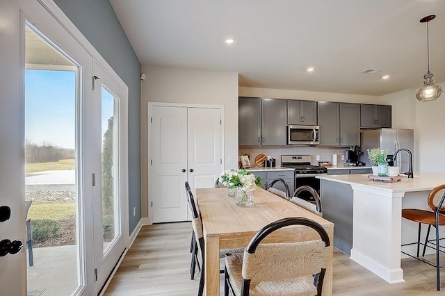 286 Subban Ct, Lebanon, TN 37087 - kitchen featuring stainless steel appliances, light countertops, light wood finished floors, a kitchen bar, and hanging light fixtures