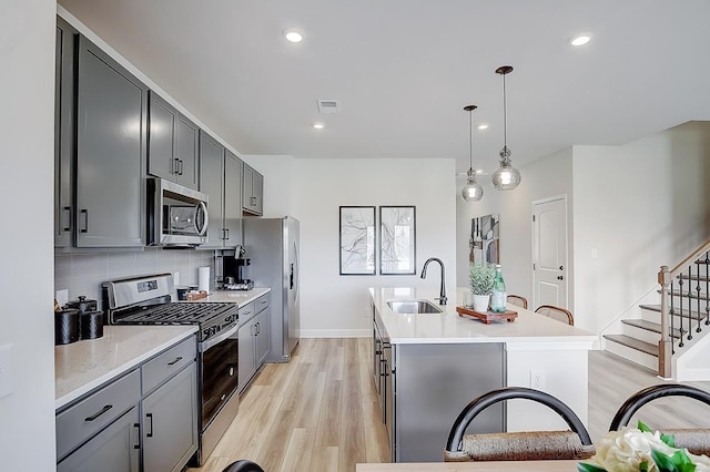 286 Subban Ct, Lebanon, TN 37087 - kitchen featuring stainless steel appliances, gray cabinets, a kitchen island with sink, light countertops, and decorative backsplash