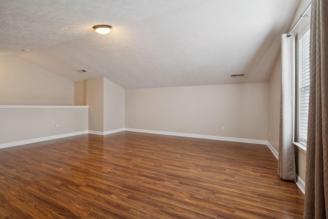 7023 Timber Oak Dr, Mount Juliet, TN 37122 - additional living space featuring vaulted ceiling, dark wood-style flooring, and a textured ceiling