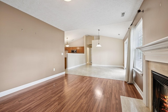 7023 Timber Oak Dr, Mount Juliet, TN 37122 - unfurnished living room with a high end fireplace, light wood finished floors, lofted ceiling, and a textured ceiling