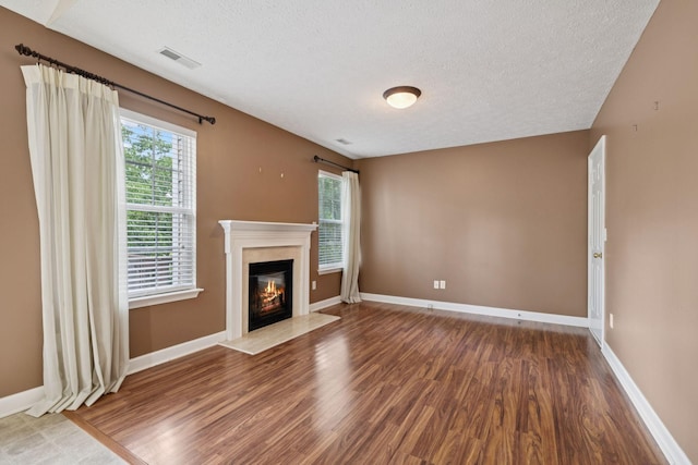 7023 Timber Oak Dr, Mount Juliet, TN 37122 - unfurnished living room with wood finished floors, a textured ceiling, plenty of natural light, and a high end fireplace