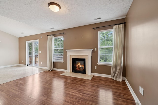 7023 Timber Oak Dr, Mount Juliet, TN 37122 - unfurnished living room featuring wood finished floors, a textured ceiling, and a fireplace with flush hearth