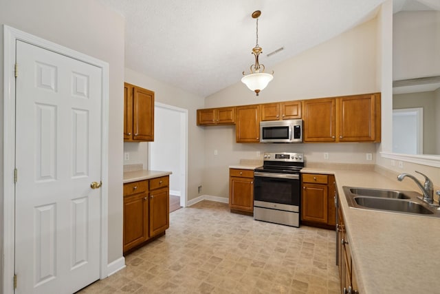 7023 Timber Oak Dr, Mount Juliet, TN 37122 - kitchen featuring stainless steel appliances, lofted ceiling, brown cabinetry, light countertops, and decorative light fixtures
