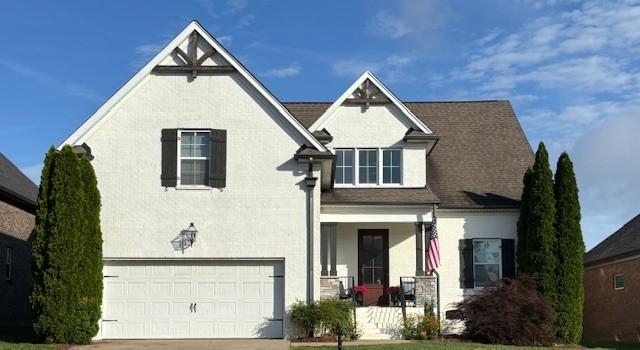 4185 Miles Johnson Pkwy, Spring Hill, TN 37174 - view of front of property with a porch, an attached garage, concrete driveway, and stucco siding