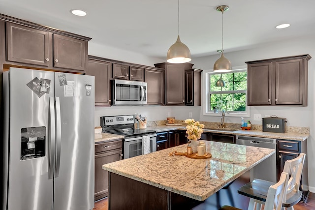 1105 Smiley Troutt Rd, Bethpage, TN 37022 - kitchen with stainless steel appliances, dark brown cabinets, a breakfast bar, light stone countertops, and a center island