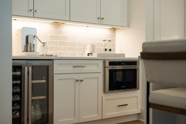 7019 Bolton St, Franklin, TN 37064 - kitchen featuring wine cooler, stainless steel oven, backsplash, and light countertops