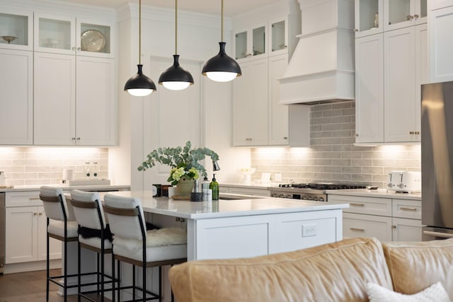 7019 Bolton St, Franklin, TN 37064 - kitchen featuring premium range hood, backsplash, light countertops, and a center island with sink