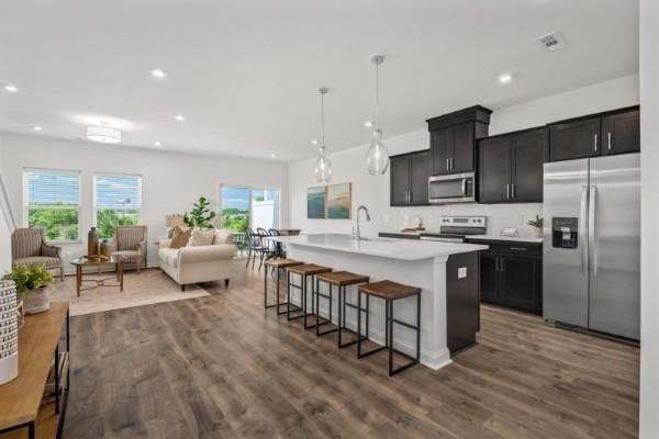 2202 Melk Ln, Columbia, TN 38401 - kitchen featuring stainless steel appliances, a kitchen bar, open floor plan, recessed lighting, and dark wood-type flooring