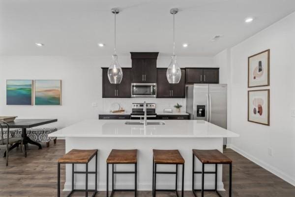 2202 Melk Ln, Columbia, TN 38401 - kitchen with appliances with stainless steel finishes, a kitchen breakfast bar, dark wood-style floors, light countertops, and recessed lighting