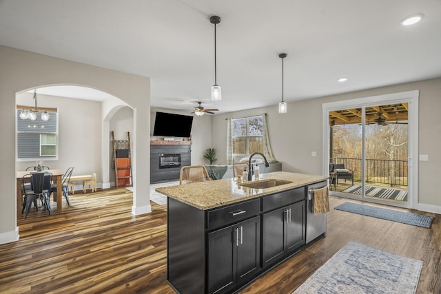 2015 Morgan Ct, Springfield, TN 37172 - kitchen featuring dishwasher, a ceiling fan, dark cabinetry, a glass covered fireplace, and light stone countertops