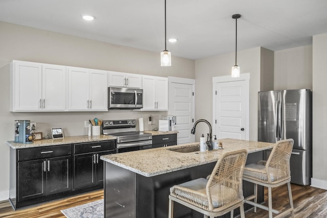 2015 Morgan Ct, Springfield, TN 37172 - kitchen with stainless steel appliances, wood finished floors, light stone countertops, a kitchen breakfast bar, and pendant lighting