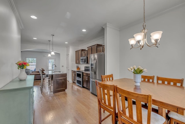 4029 Viola Ln, Franklin, TN 37069 - dining room with arched walkways, light wood-style floors, a chandelier, ornamental molding, and recessed lighting