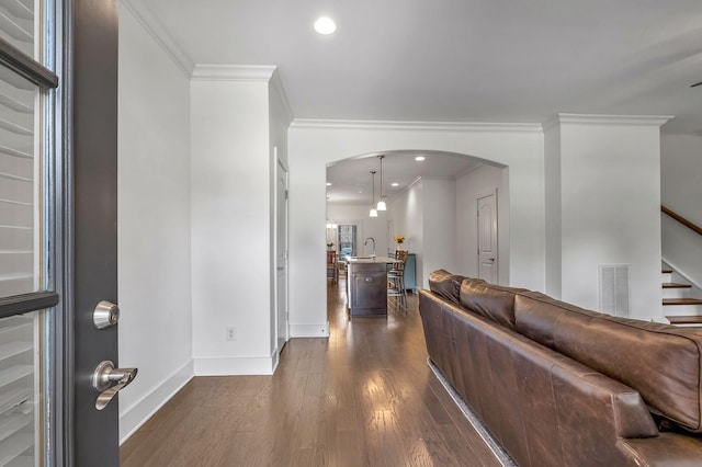 4029 Viola Ln, Franklin, TN 37069 - living room with crown molding, arched walkways, dark wood finished floors, and stairway