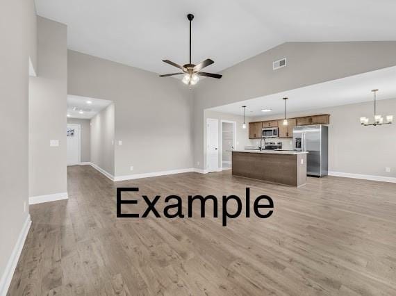 153 Irish Hls, Clarksville, TN 37042 - unfurnished living room featuring wood finished floors, a ceiling fan, a chandelier, and high vaulted ceiling