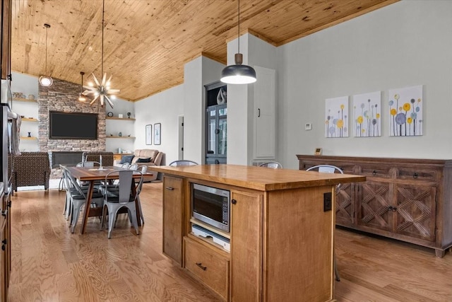 2006 Goodrich Rd, Nunnelly, TN 37137 - kitchen featuring stainless steel microwave, wooden ceiling, light wood finished floors, open floor plan, and a center island