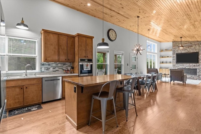 2006 Goodrich Rd, Nunnelly, TN 37137 - kitchen with appliances with stainless steel finishes, wood ceiling, high vaulted ceiling, brown cabinets, and light wood-type flooring