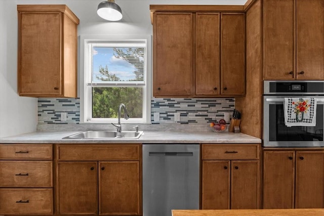 2006 Goodrich Rd, Nunnelly, TN 37137 - kitchen featuring stainless steel appliances, decorative backsplash, light countertops, and brown cabinetry