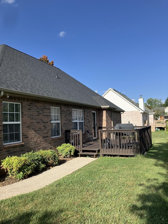 809 Renaissance Ave, Murfreesboro, TN 37129 - back of house with brick siding, a shingled roof, a wooden deck, and a lawn